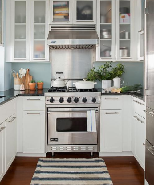 A kitchen with white cabinets and stainless steel appliances