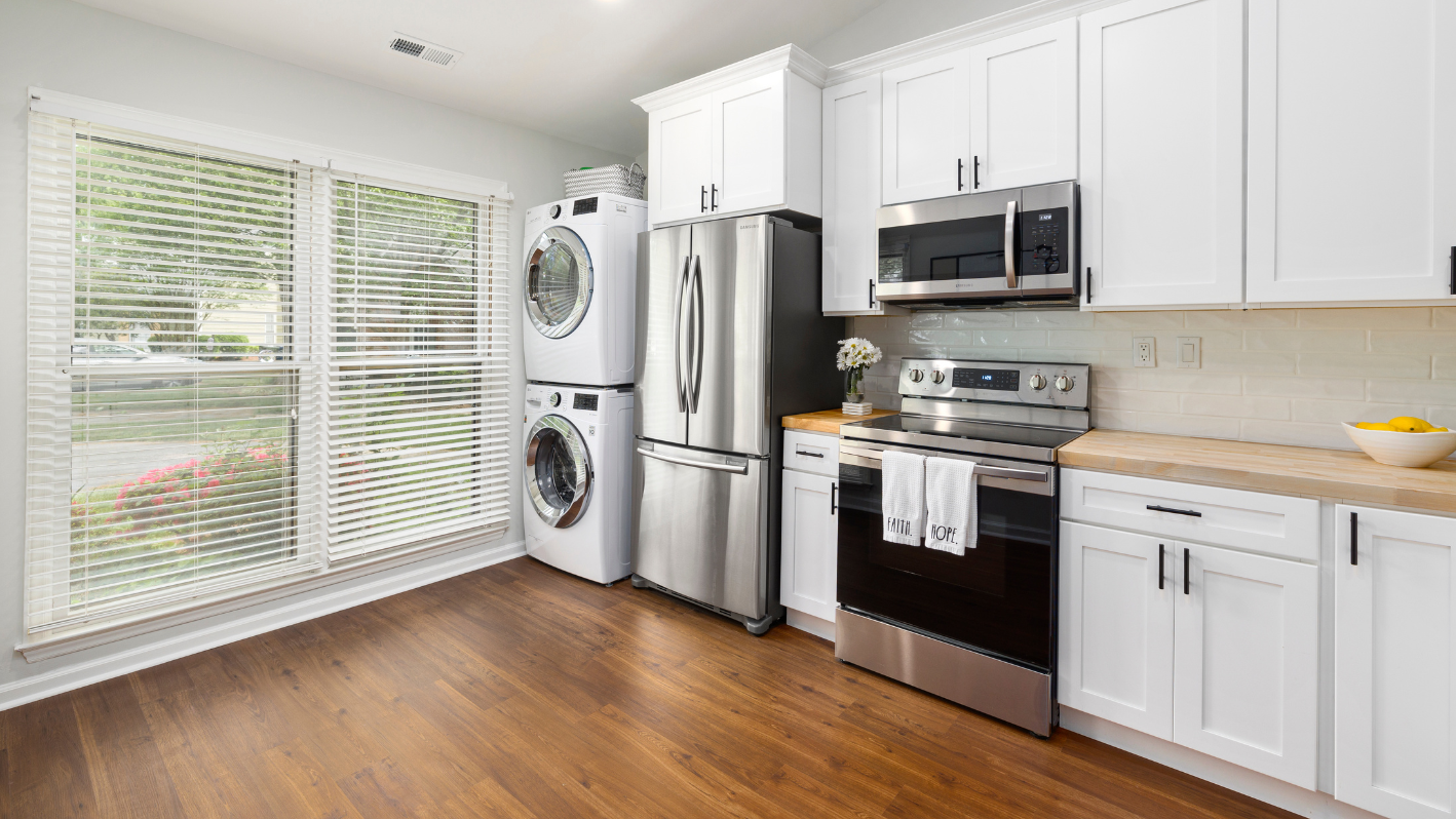 A kitchen with white cabinets and stainless steel appliances